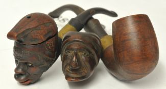 Two carved wood face pipes and another (3).
