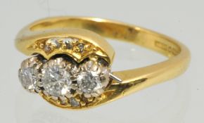 18ct three stone diamond ring, set with further small diamonds in yellow gold, stamped 750, Size H,