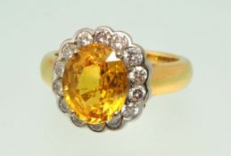 18ct yellow gold sapphire and diamond cluster ring, the oval yellow sapphire approximately 5.5