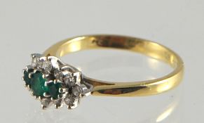 A modern emerald and diamond cluster ring set in 18ct gold stamped .750, size L
