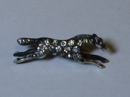 Silver brooch formed as a horse mid gallop, set with white stones and a small pink stone for the