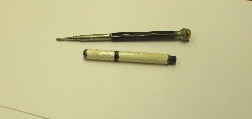 Pencil with pale cream engine turned enamel barrel and cap, overall length 9cm; and a propelling