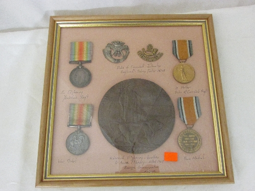 **amended catalogue description**Framed group of family war medals and cap badges including; 1914-18