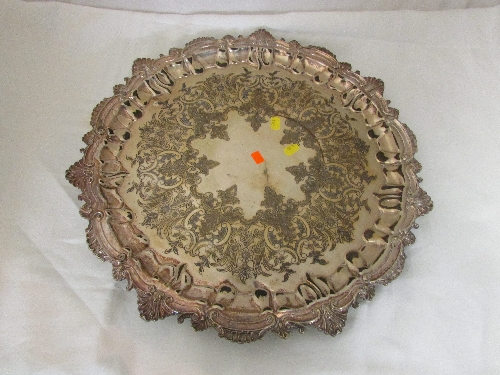 Engraved circular electroplated tray with a stylized foliate rococo edge, standing on three small