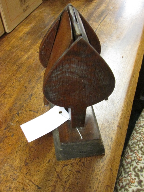 Treen object on rectangular base, in profile resembling the spade suit symbol and perhaps a