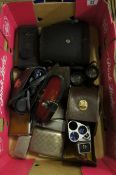 A collection of vintage camera binoculars and cigarette boxes. 14 in total.