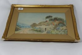 A watercolour painting of a Country cottage by Tom Williams in a gilt frame 50cm x 32cm