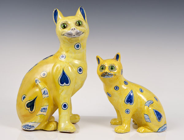 Late nineteenth century Emile Gallé yellow glazed faience cat with glass eyes and blue and white