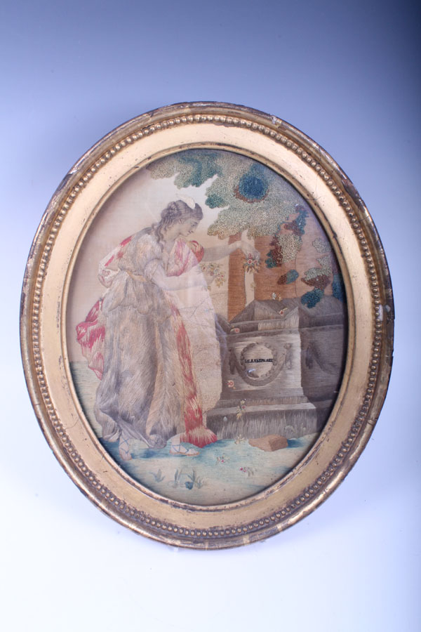 Late eighteenth century George III oval silk work picture of a woman beside Shakespeare's tomb, in