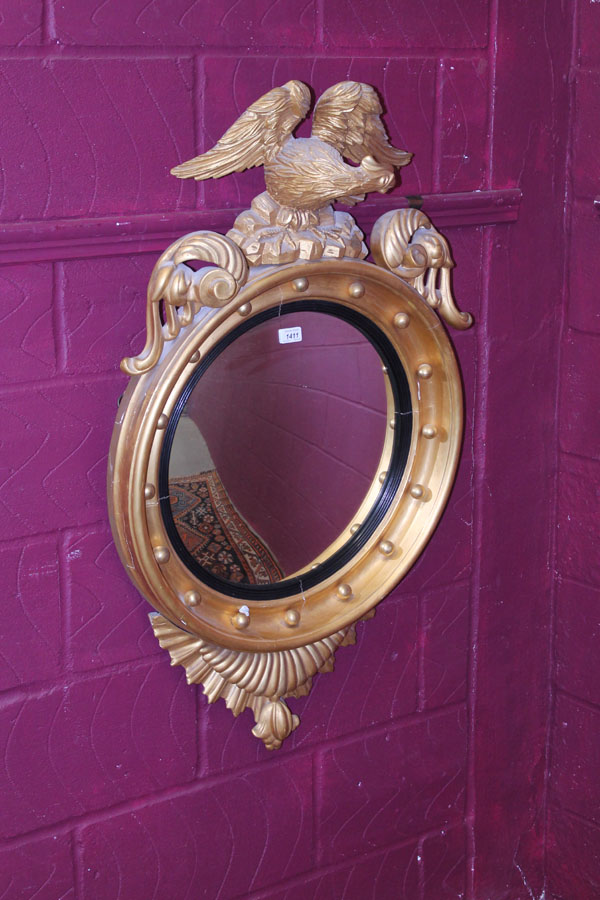 Impressive nineteenth century gilt framed convex wall mirror with eagle and scroll mounts, gilt ball