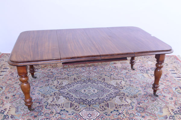 Victorian mahogany extending dining table with two extra leaves on turned legs and brass capped