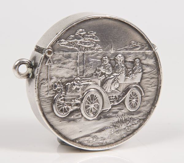 Unusual Edwardian silver vesta case of circular form, embossed with a period motoring scene,