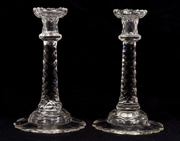 Pair nineteenth century cut glass candlesticks with facet cut stems on facet cut petal-shaped bases,