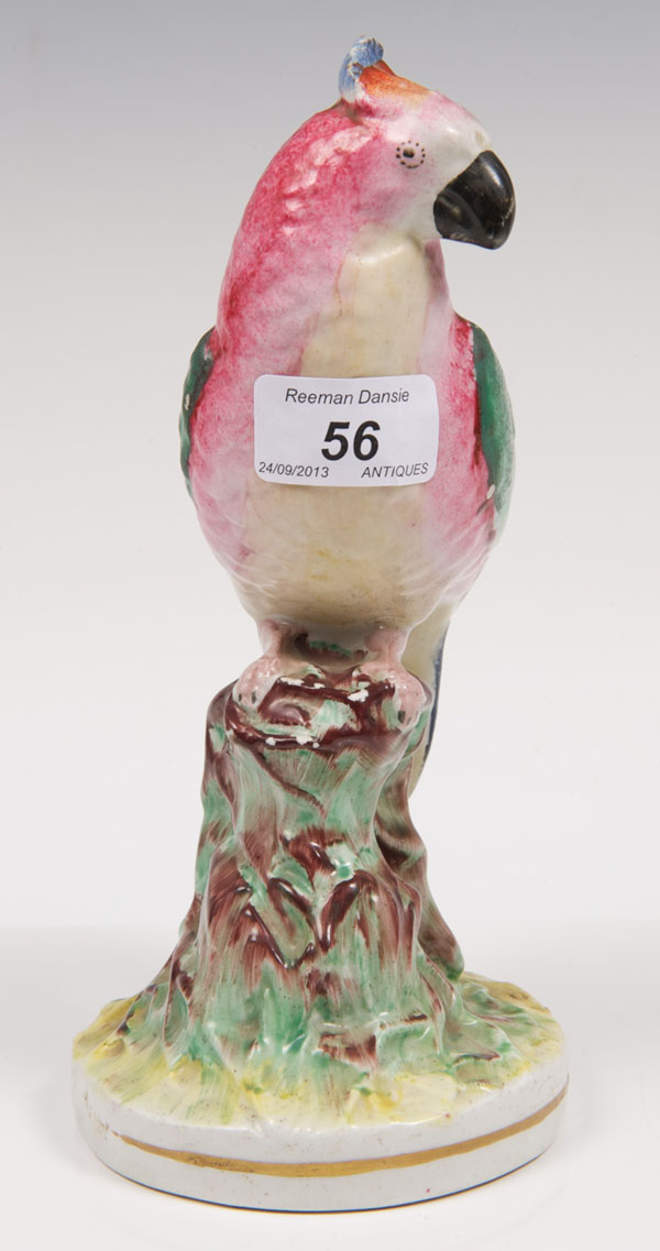 Victorian Staffordshire figure of a parrot perched on a stump, with polychrome painted decoration,