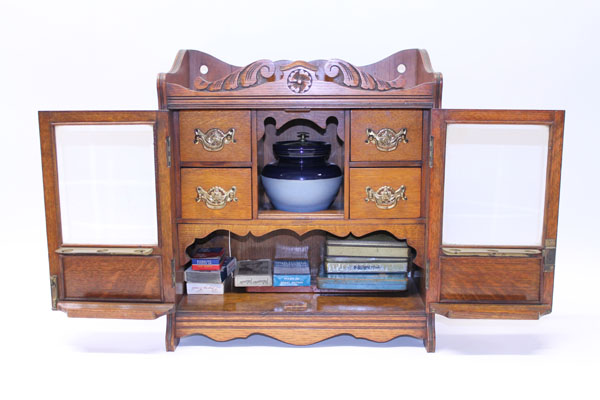 Edwardian oak smokers' compendium with four drawers, central shelf with 'Bourne Denby' blue