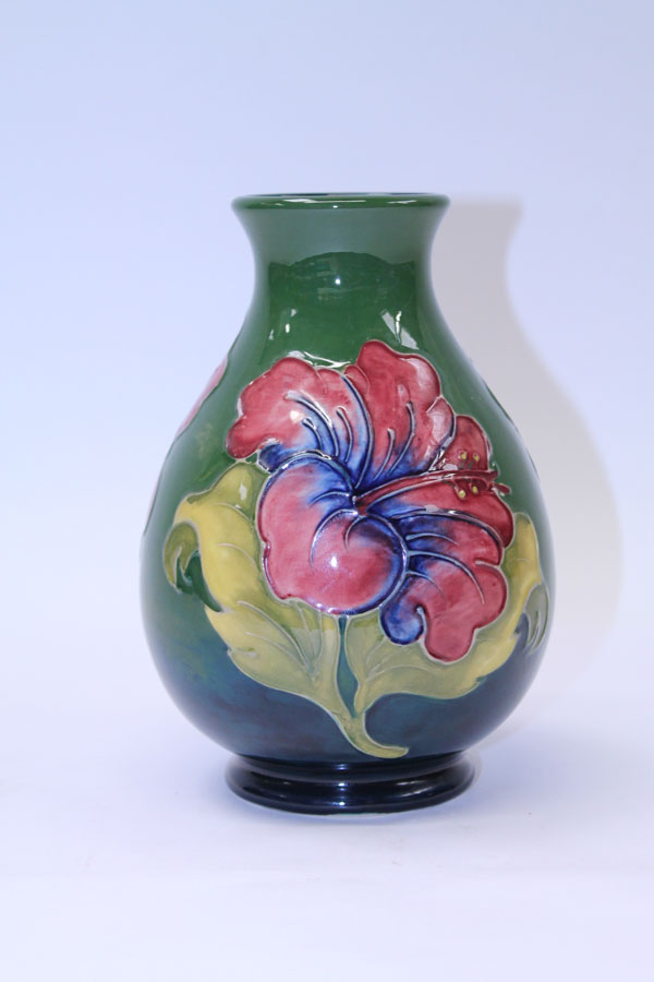 Moorcroft pottery vase decorated in the Hibiscus pattern on green and blue ground, impressed and