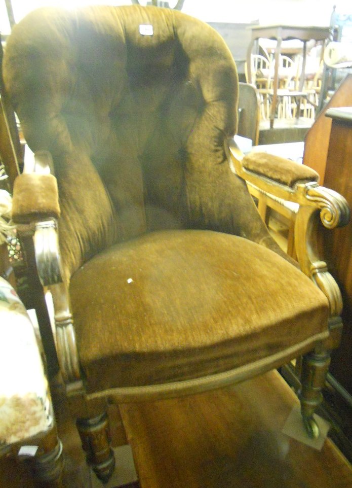 A William IV rosewood framed armchair with button back, set on turned front legs and brass casters