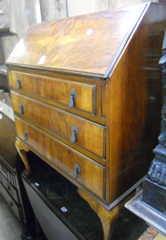 A mahogany fall-front bureau with fitted interior and three graduated drawers, on cabriole legs