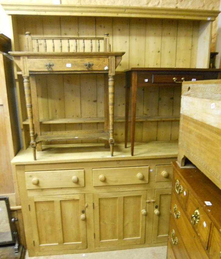 A 6’2” late Victorian stripped pine dresser with two shelf open plate rack, over a base with three