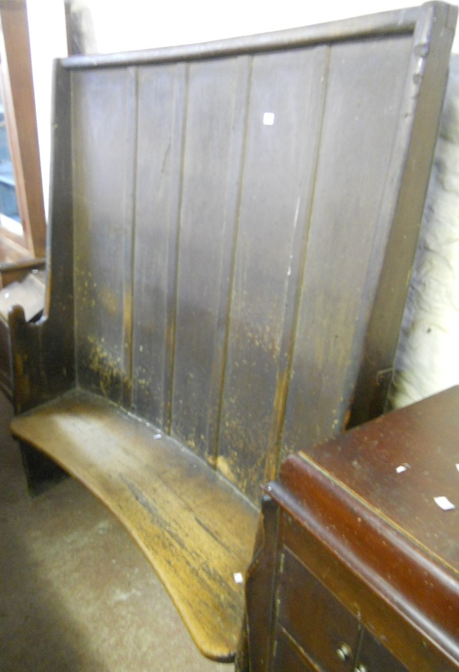 A 4’5” 18th Century stained wood curved settle with panelled back and solid seats