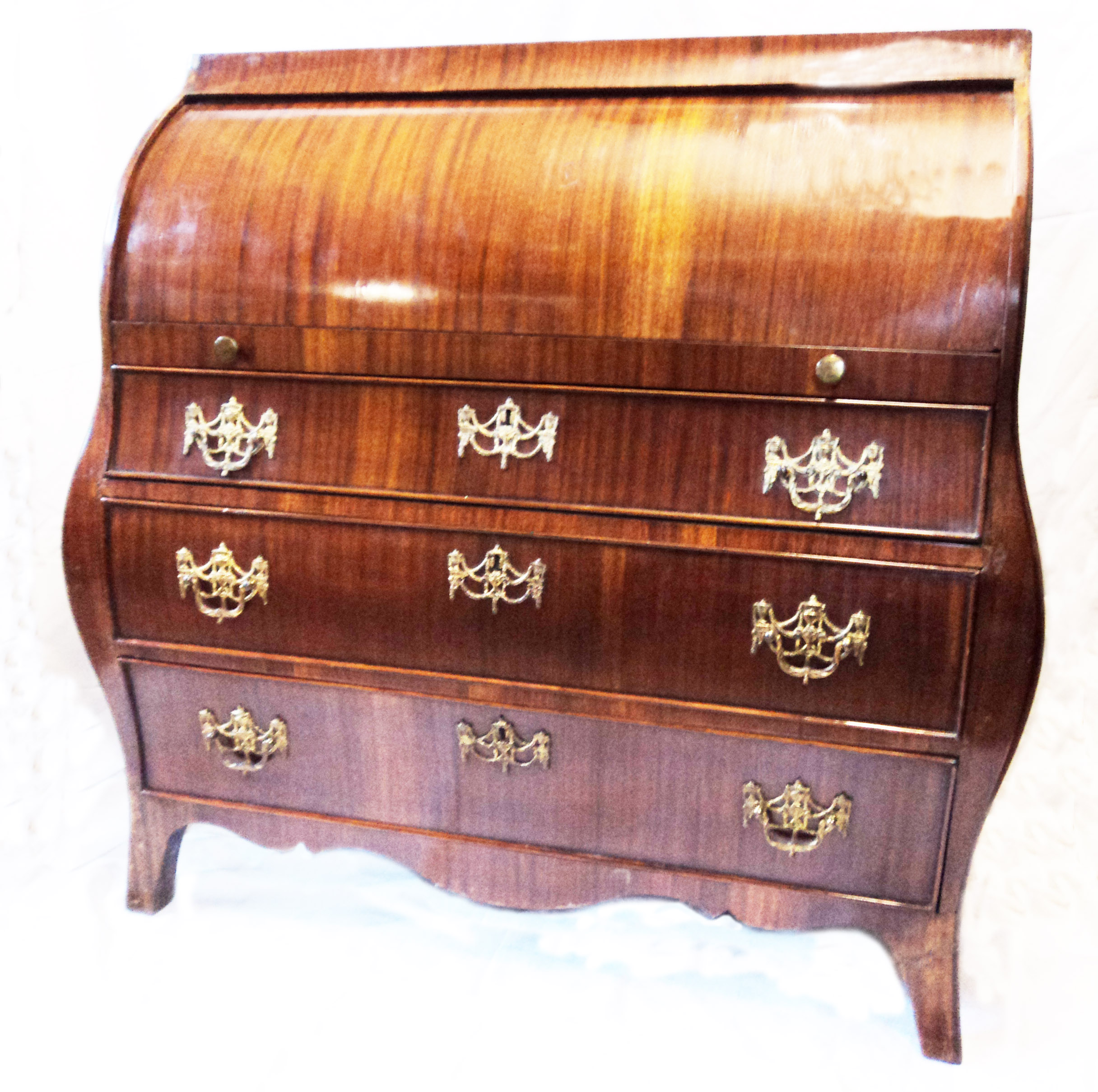 A 3’4” mahogany barrel top bombe bureau with fitted interior over three graduated drawers with