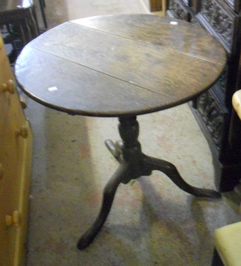 An 18th Century oak circular tilt-top side table with splayed tripod base