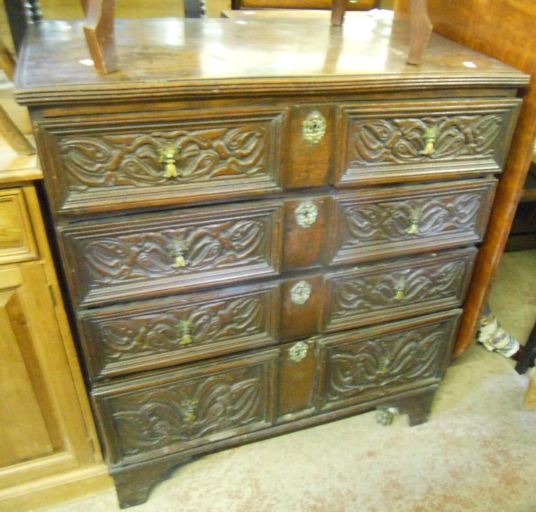 A 3’ antique elm topped chest of four graduated drawers, with ornately carved front, brass handles