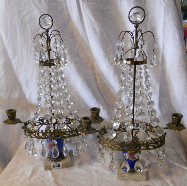 A pair of French style candlesticks with lustre drops, set on onyx bases