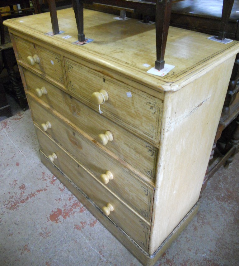 A 4’7” stained and grained pine chest of two short and three long graduated drawers, set on plinth