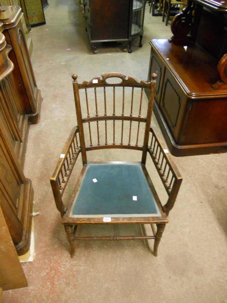 A stained beech spindle back elbow chair with upholstered seat