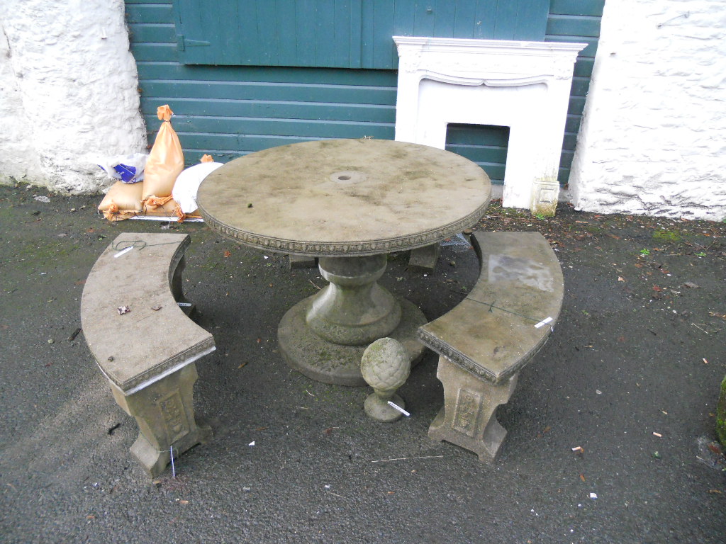 A concrete circular garden table with pine cone finial and a baluster column base - sold with