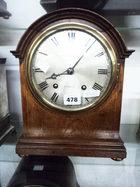 An inlaid oak cased bracket clock retailed by Camerer Kuss & Co., London, with silvered dial and