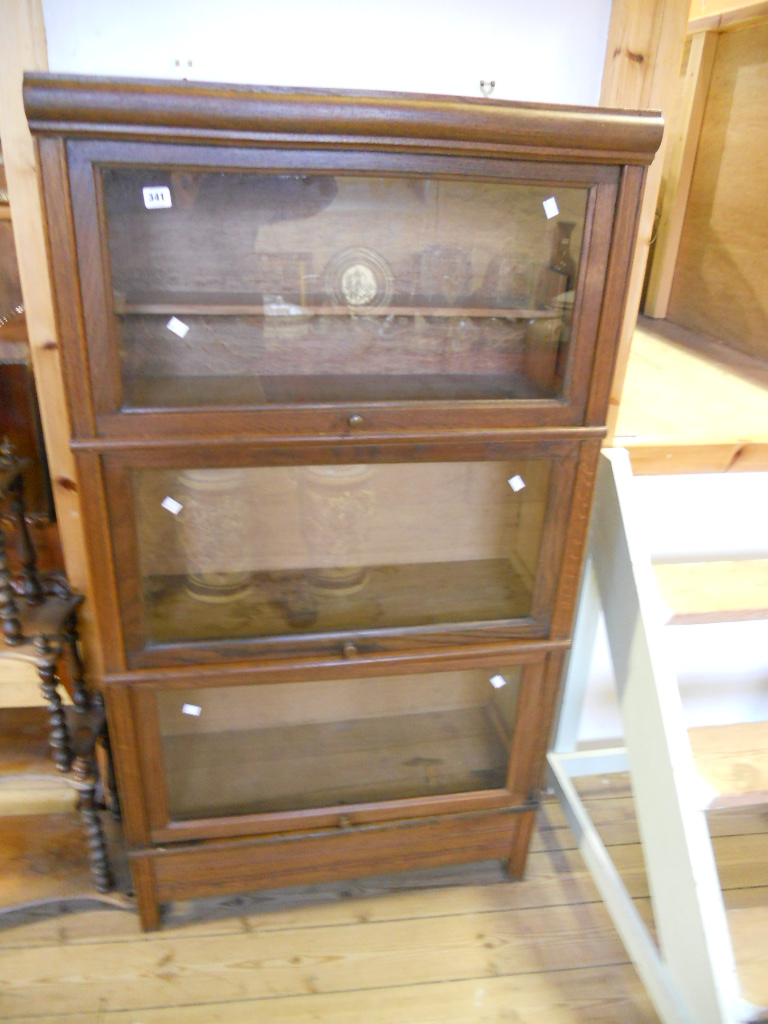 A 32” French oak three section glazed front bookcase with Globe Wernicke style action