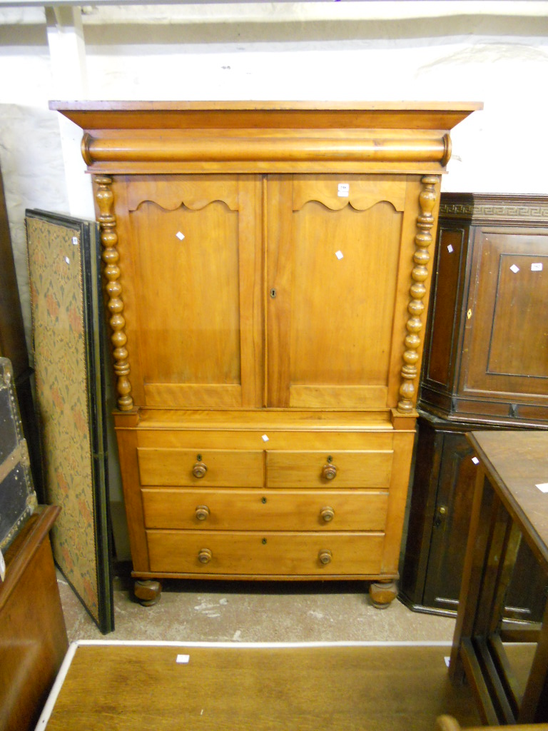 A 3’10” 19th Century mahogany linen press with flanking turned bobbin decoration, interior shelves