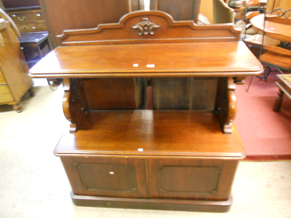 A 4’ Victorian mahogany two tier buffet, with raised top, flanking scroll ends and cupboards to