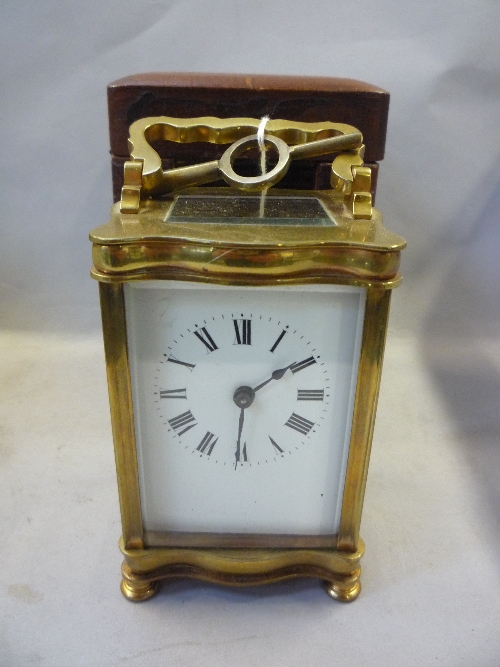 A BRASS CARRIAGE TIMEPIECE, early 20th Century, serpentine corniche case, enamel Roman dial,