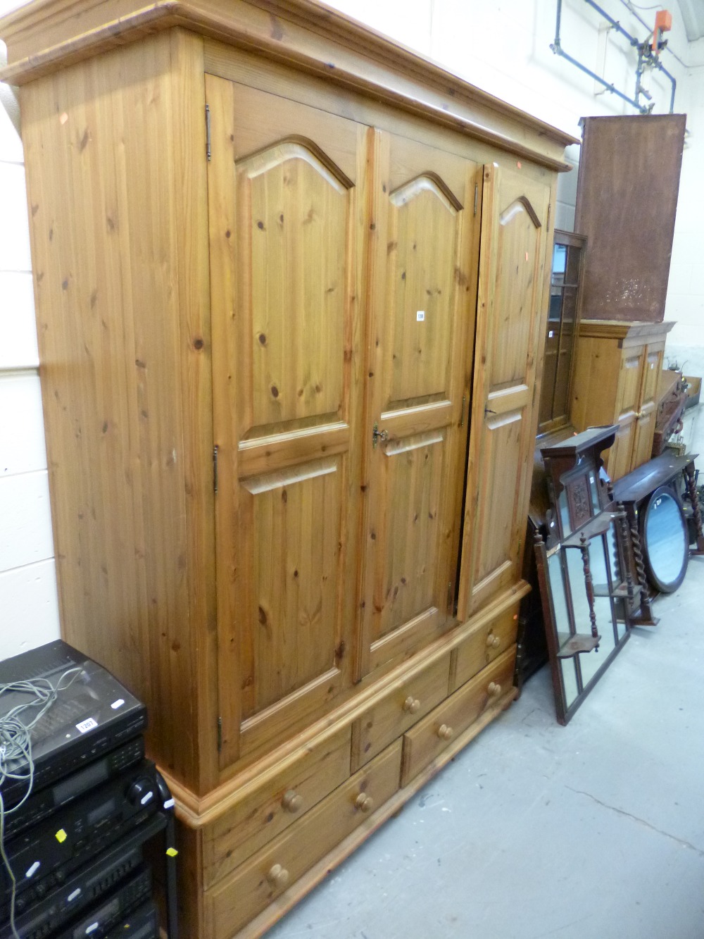 A LARGE PINE TRIPLE DOOR WARDROBE with drawers below (s.d.)