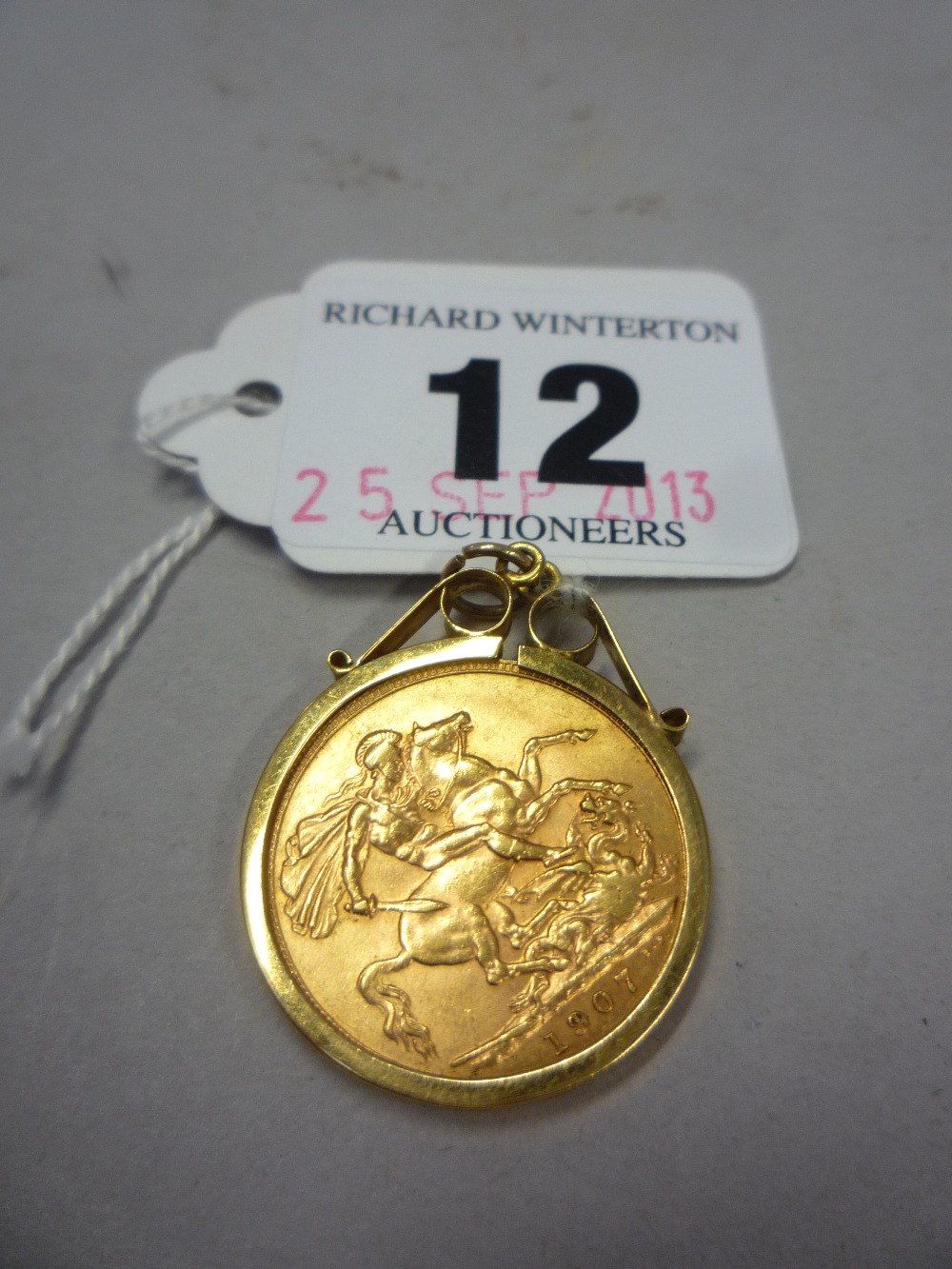 A 1907 GOLD SOVEREIGN, mounted in 9ct (approximately 10g)