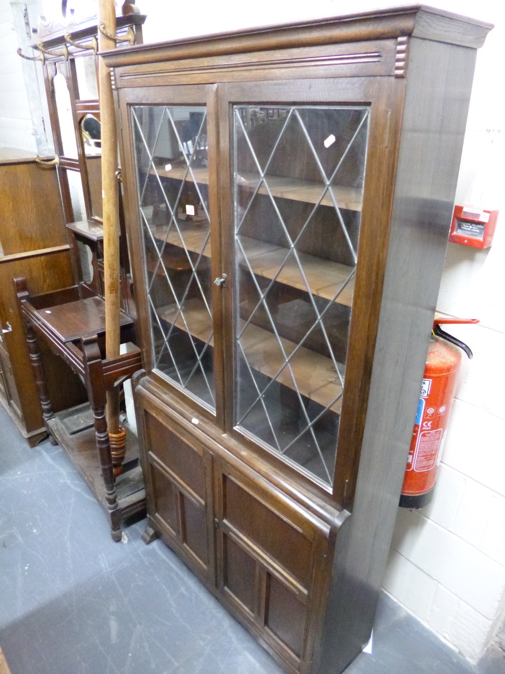 AN OAK LEAD GLAZED BOOKCASE WITH CUPBOARD BELOW