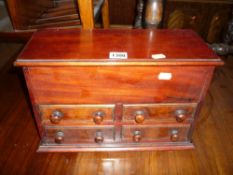 A MINIATURE MAHOGANY CHEST of four drawers with lift up top