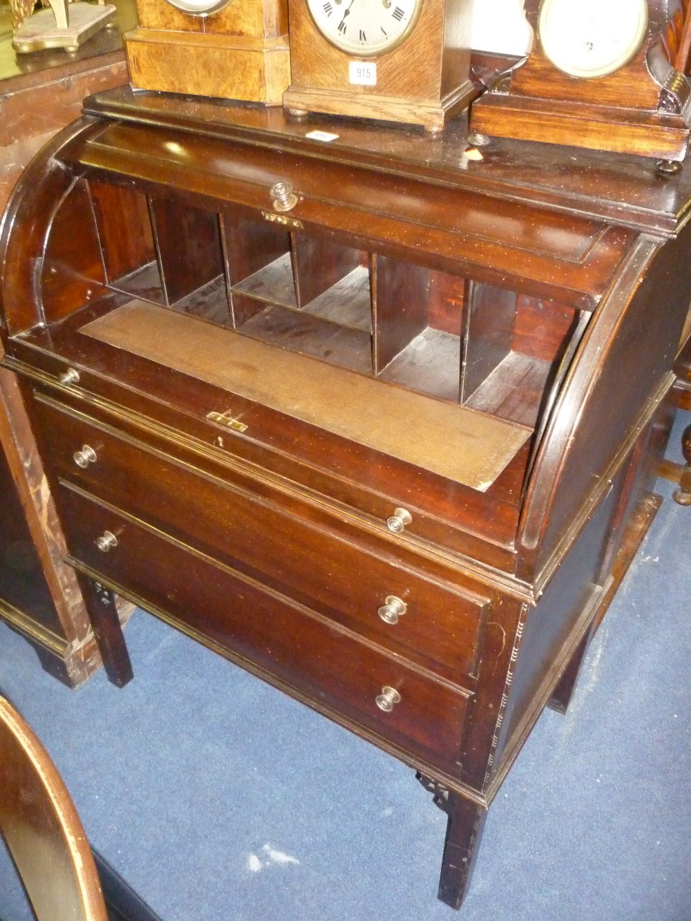 A small Edwardian mahogany barrel fronted desk with pull out writing area and two drawers below
