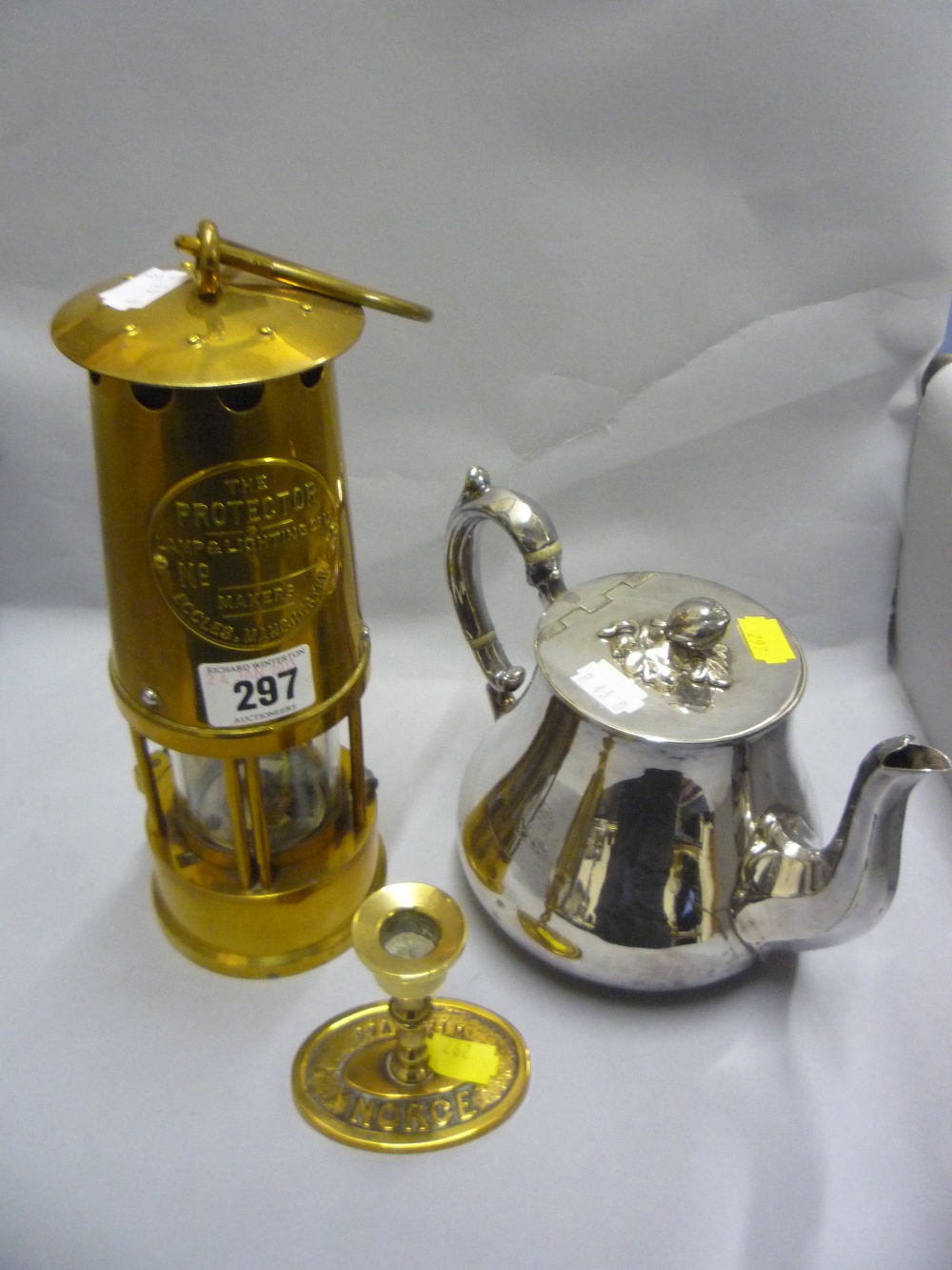 A brass protector lamp, a candlestick and a plated teapot (3)