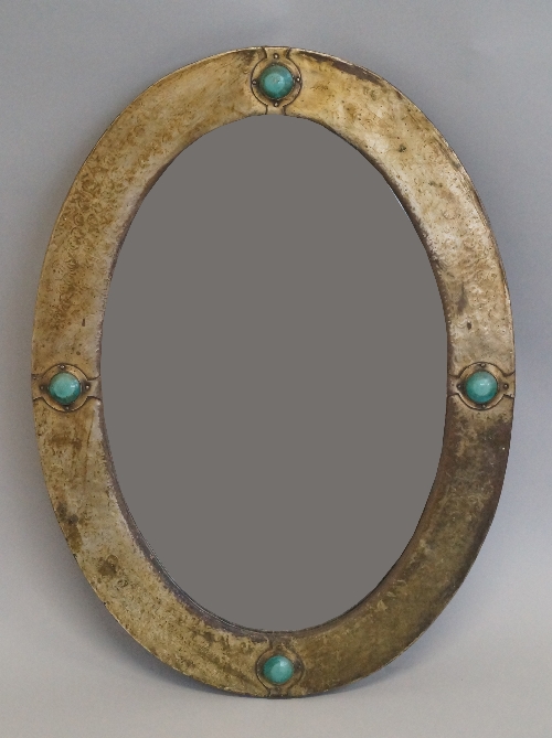 A Liberty style arts and crafts mirror, late 19th/ early 20th century, of oval form with bevelled