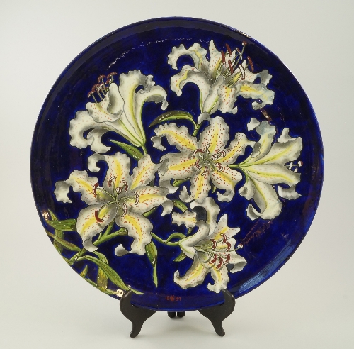 A T.C. Brown Westhead Moore & Co pottery charger, c.1884, decorated with large lilies over royal