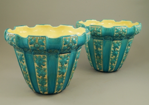 A pair of Burmantofts blue faience jardinieres, c.1863, the shaped tops with panels having raised