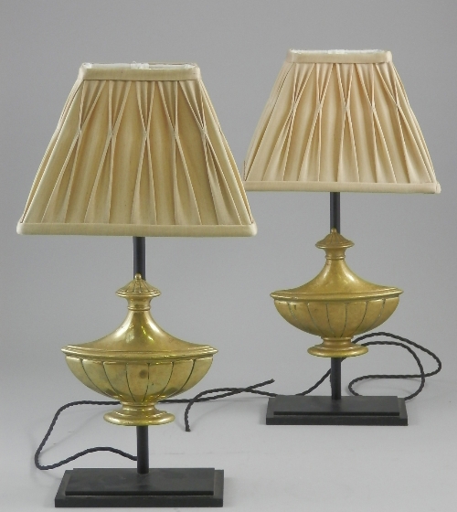 A pair of contemporary black metal table lights fitted with brass urn mouldings, central column