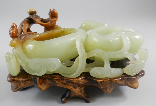 A Chinese carved jadeite double well brush washer, Qing Dynasty, the twin wells surrounded by