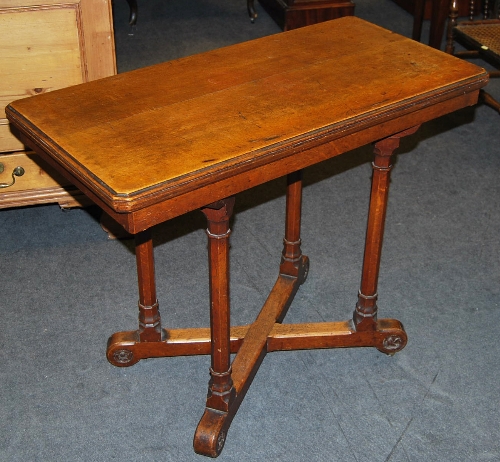 A late Victorian carved oak card table, the hinged top enclosing a baize lined interior, raised on