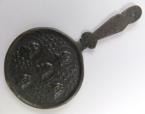 A Persian bronze mirror, possibly Ilkhanid period, of circular form, the shaped handle leading to