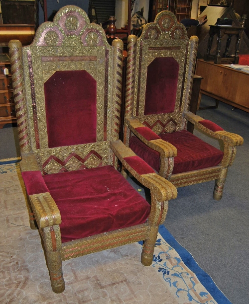 A pair of unusual Indian hard wood thrown chairs, with dark maroon upholstery, the frames covered